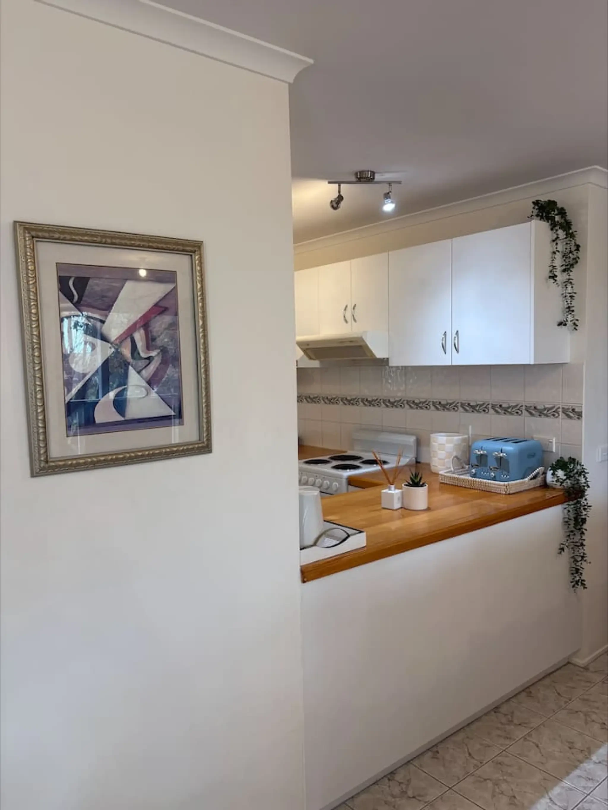 Pine Lea Lodge kitchen with white cabinetry and artwork