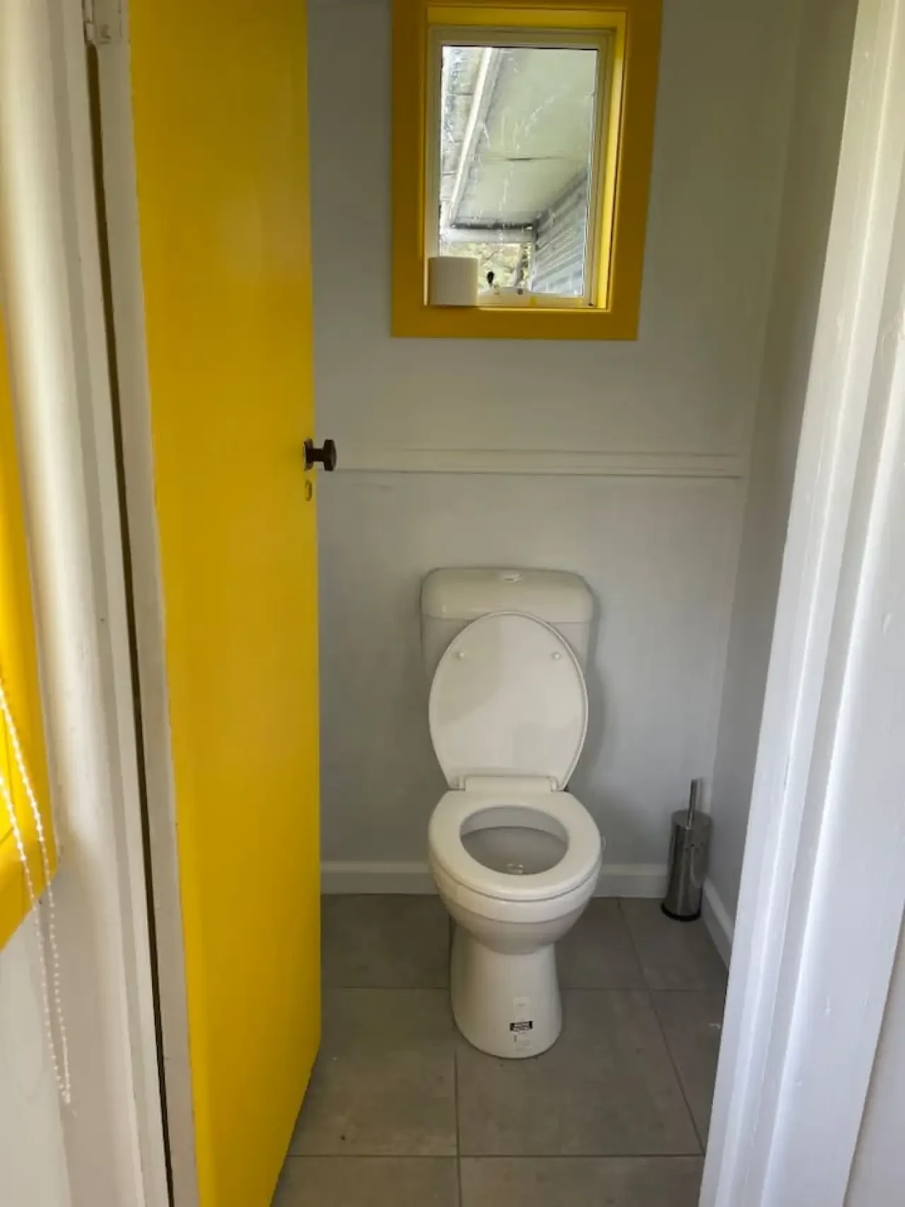 Cosy Tin Shack separate toilet with yellow door