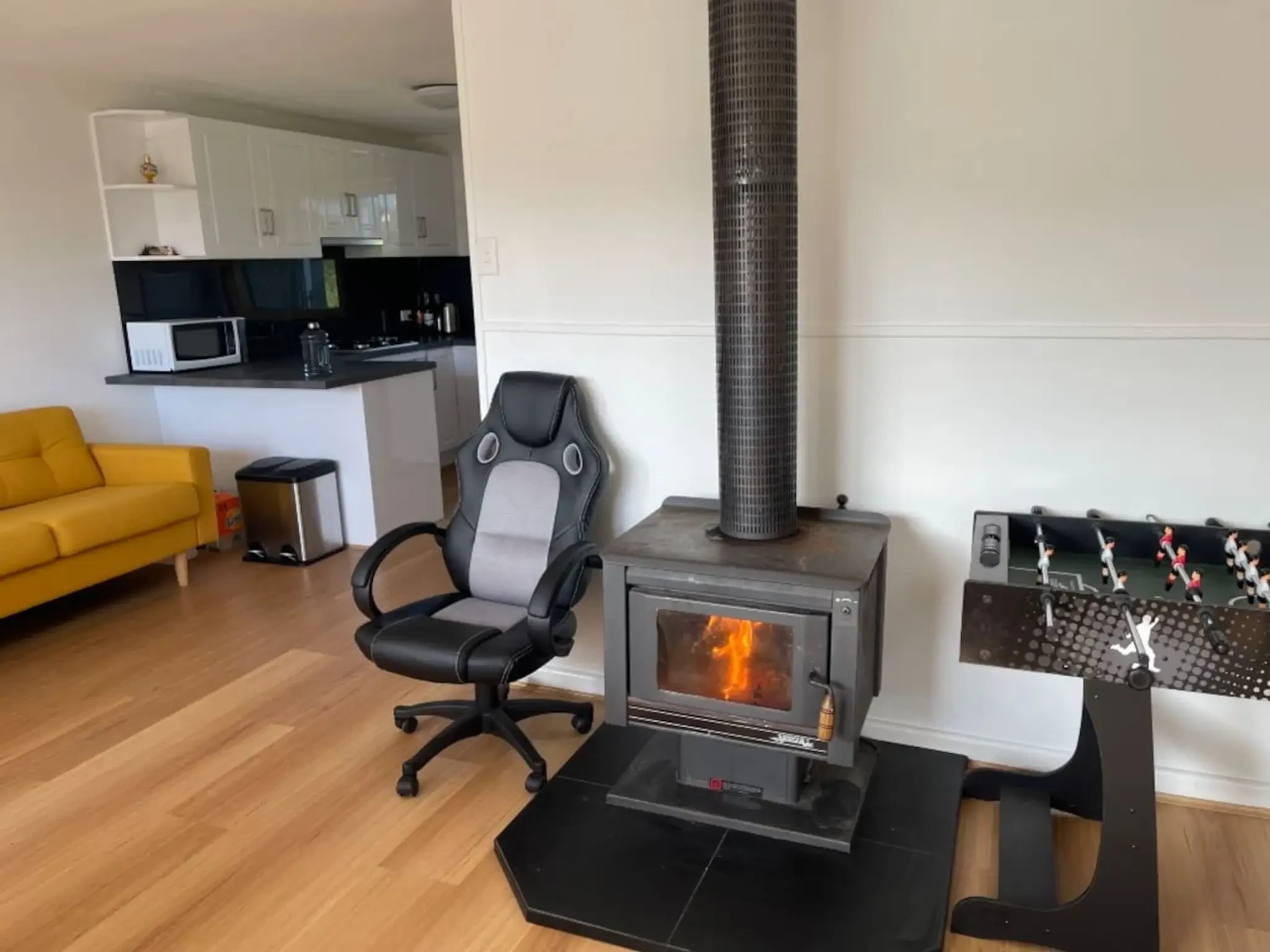 Cosy Tin Shack living area with wood fire and foosball table
