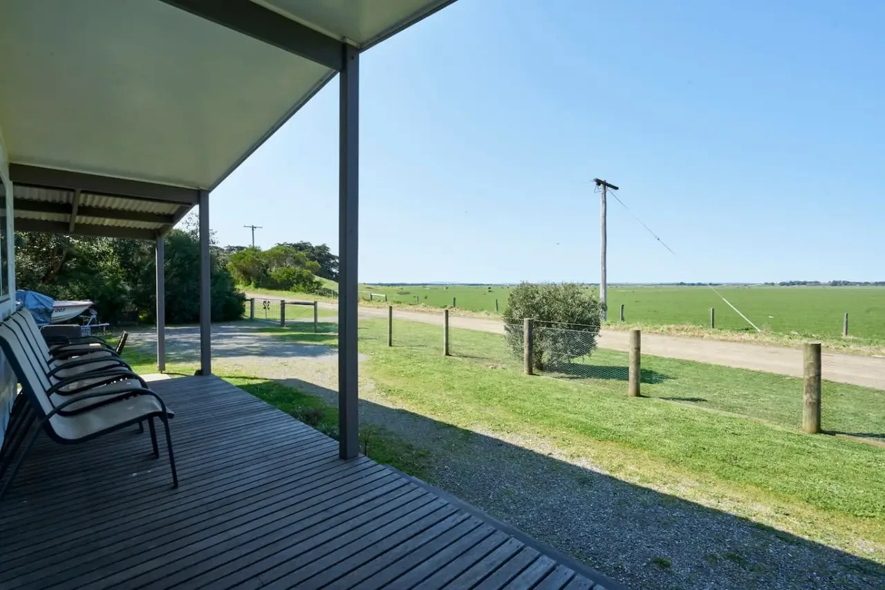 Far View covered deck with lounge chairs overlooking green paddocks