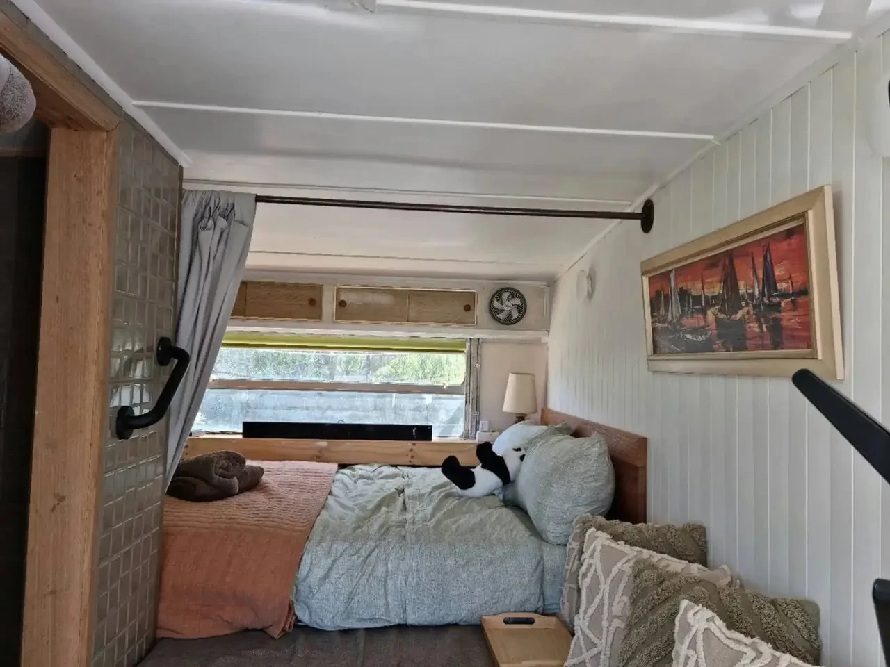 Far View caravan interior bedroom with timber panelling and artwork