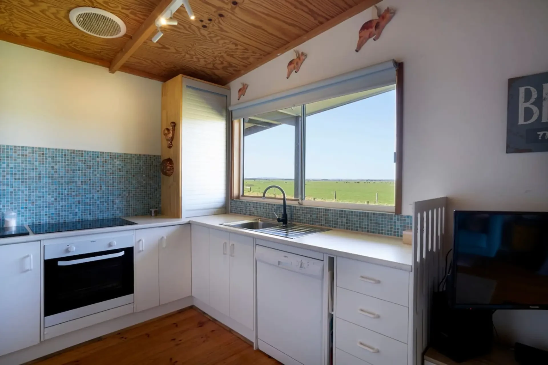 Far View kitchen with blue mosaic tiles, white cabinetry and paddock views
