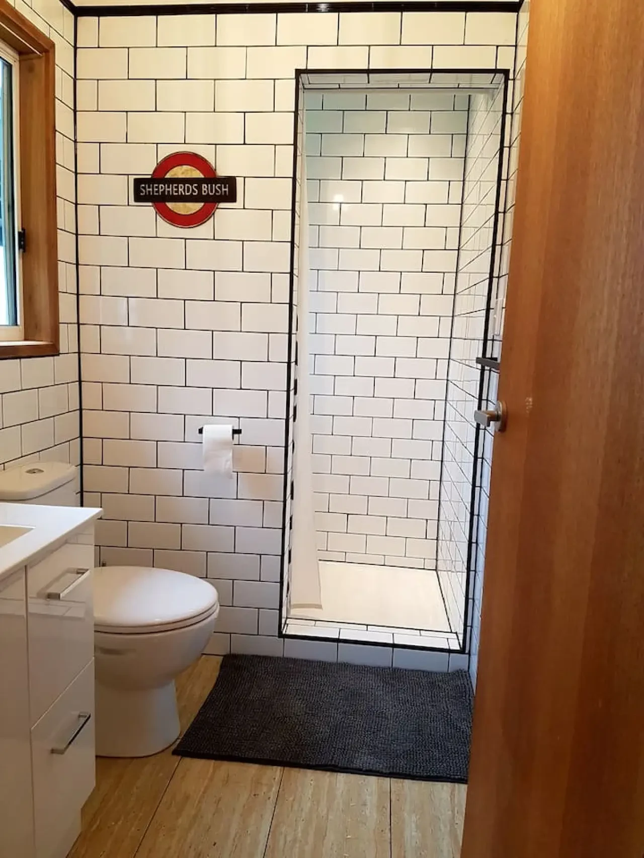 Far View bathroom with subway tiles and Shepherds Bush sign