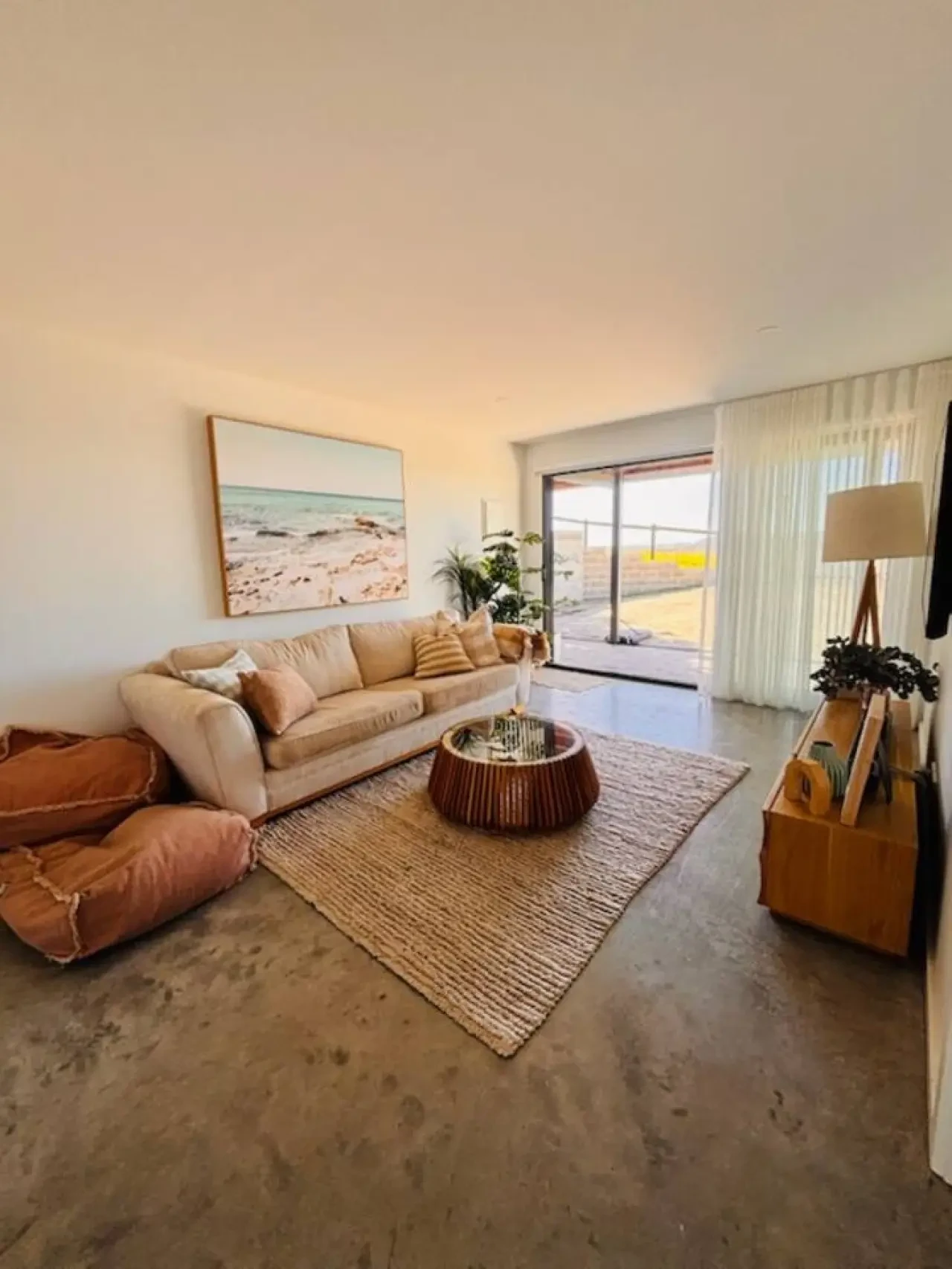 Lancaster Lodge living room with coastal artwork, beige sofa and deck views