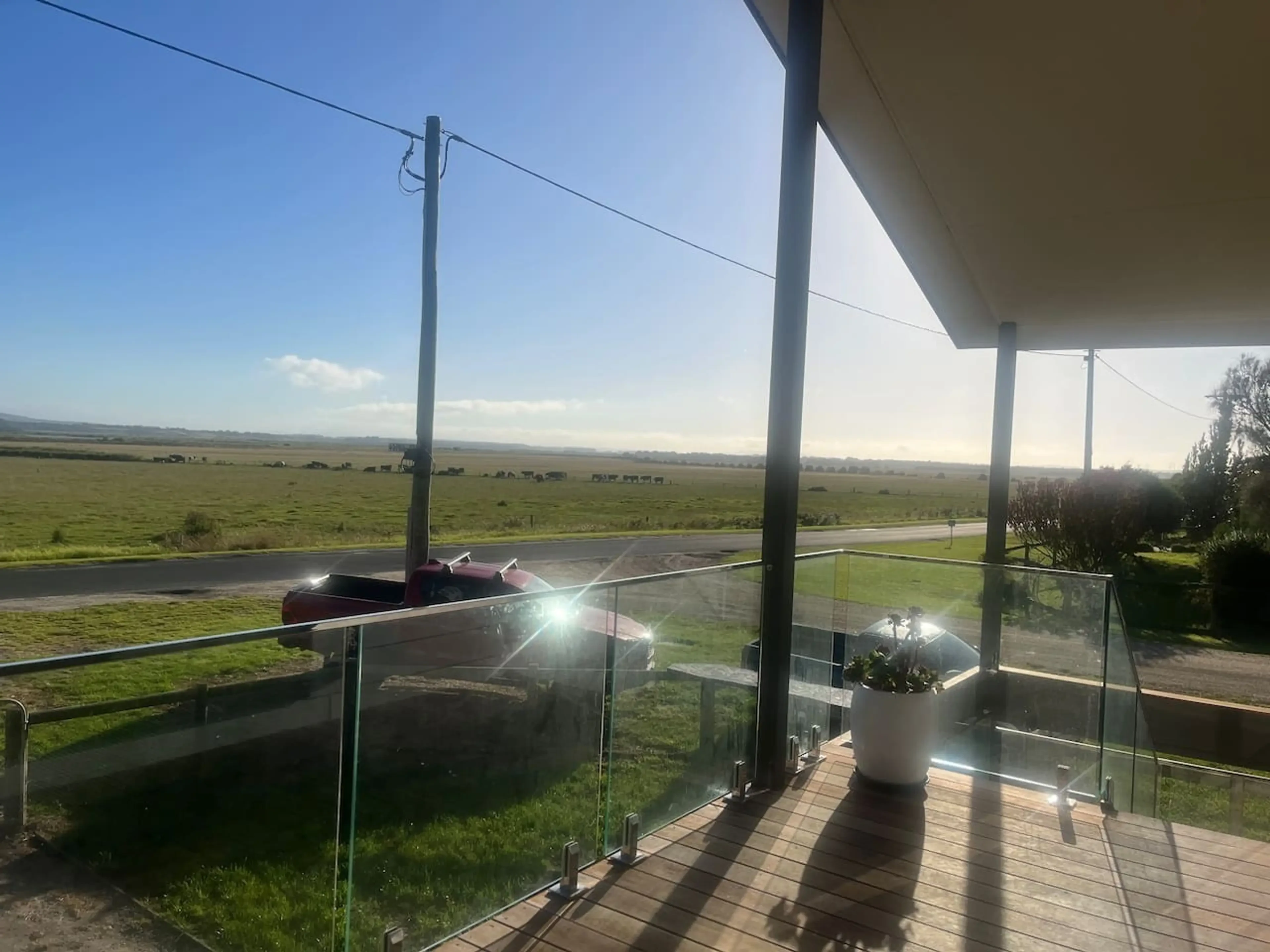 Lancaster Lodge deck with glass railings overlooking open paddocks