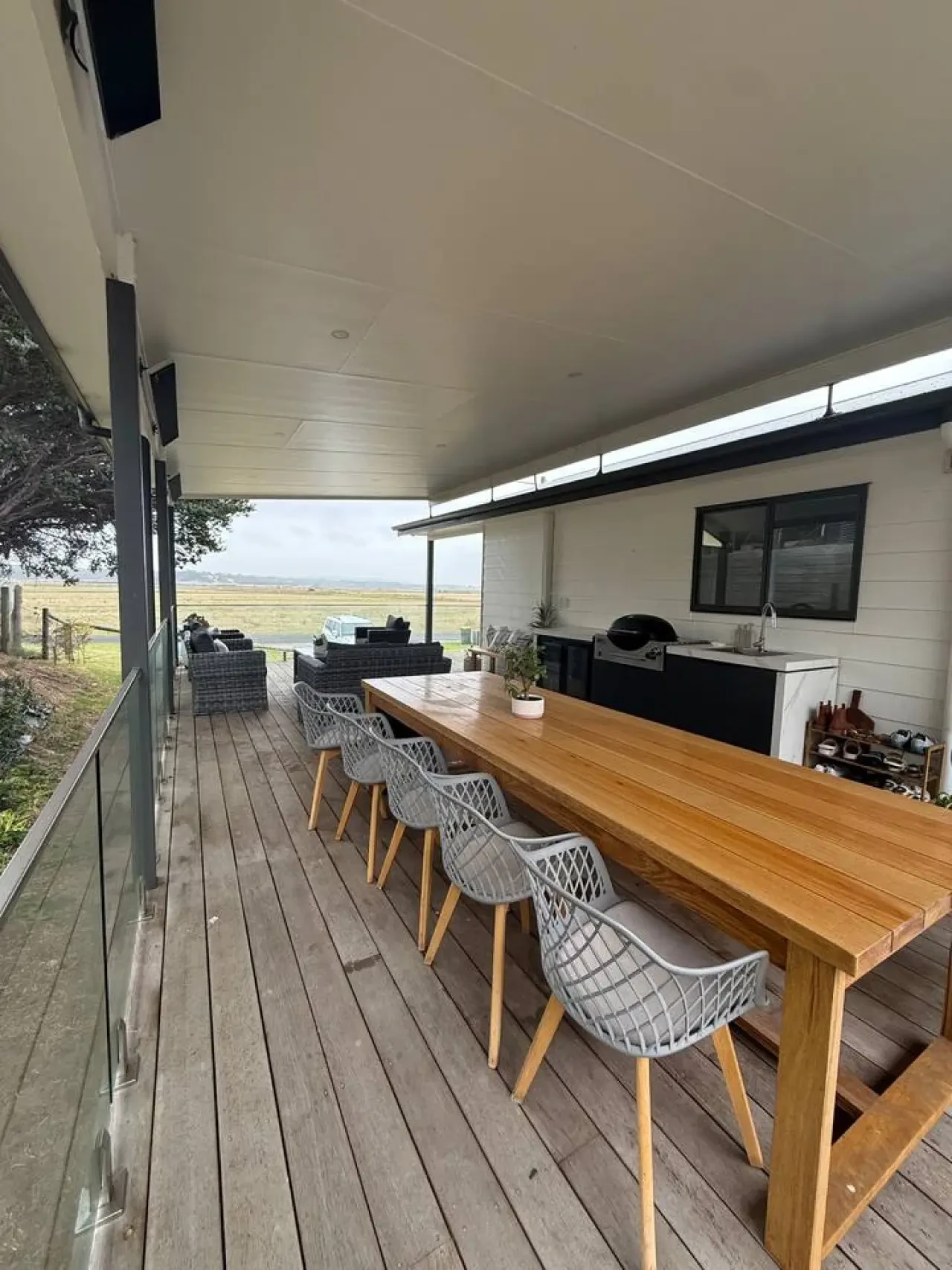 Lancaster Lodge deck with large timber dining table and rural views