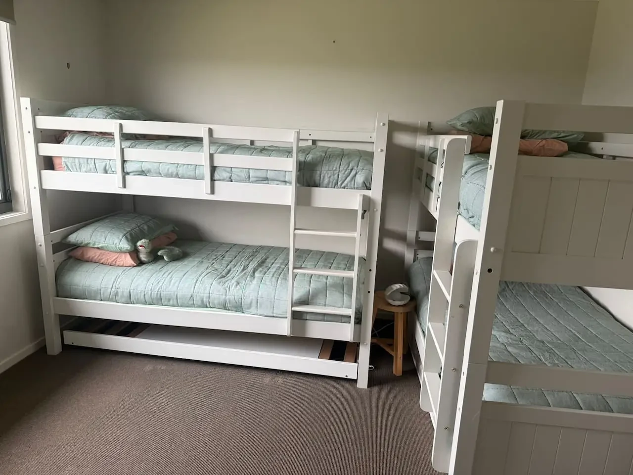 Lancaster Lodge bunk room with two sets of white bunk beds and green bedding