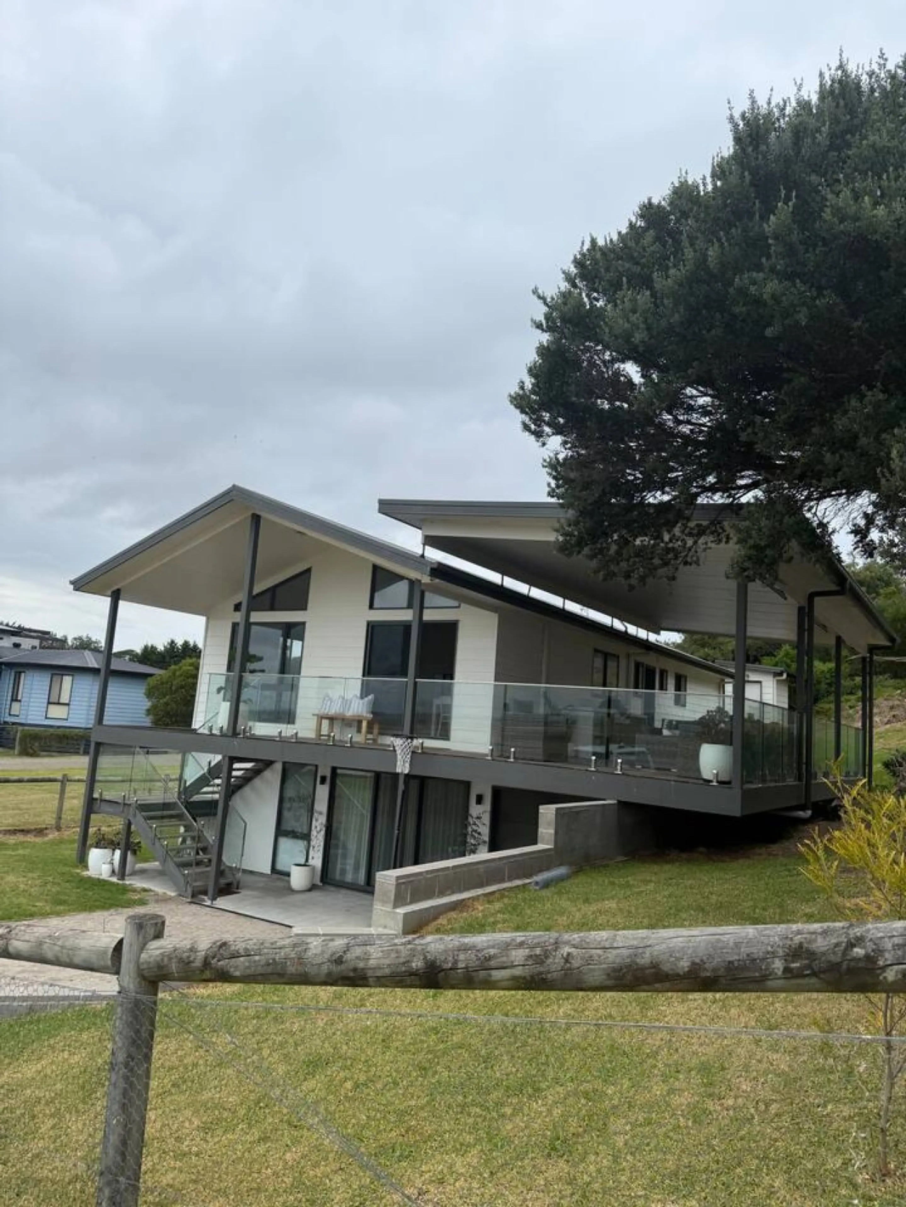 Lancaster Lodge exterior side view with elevated deck and lawn