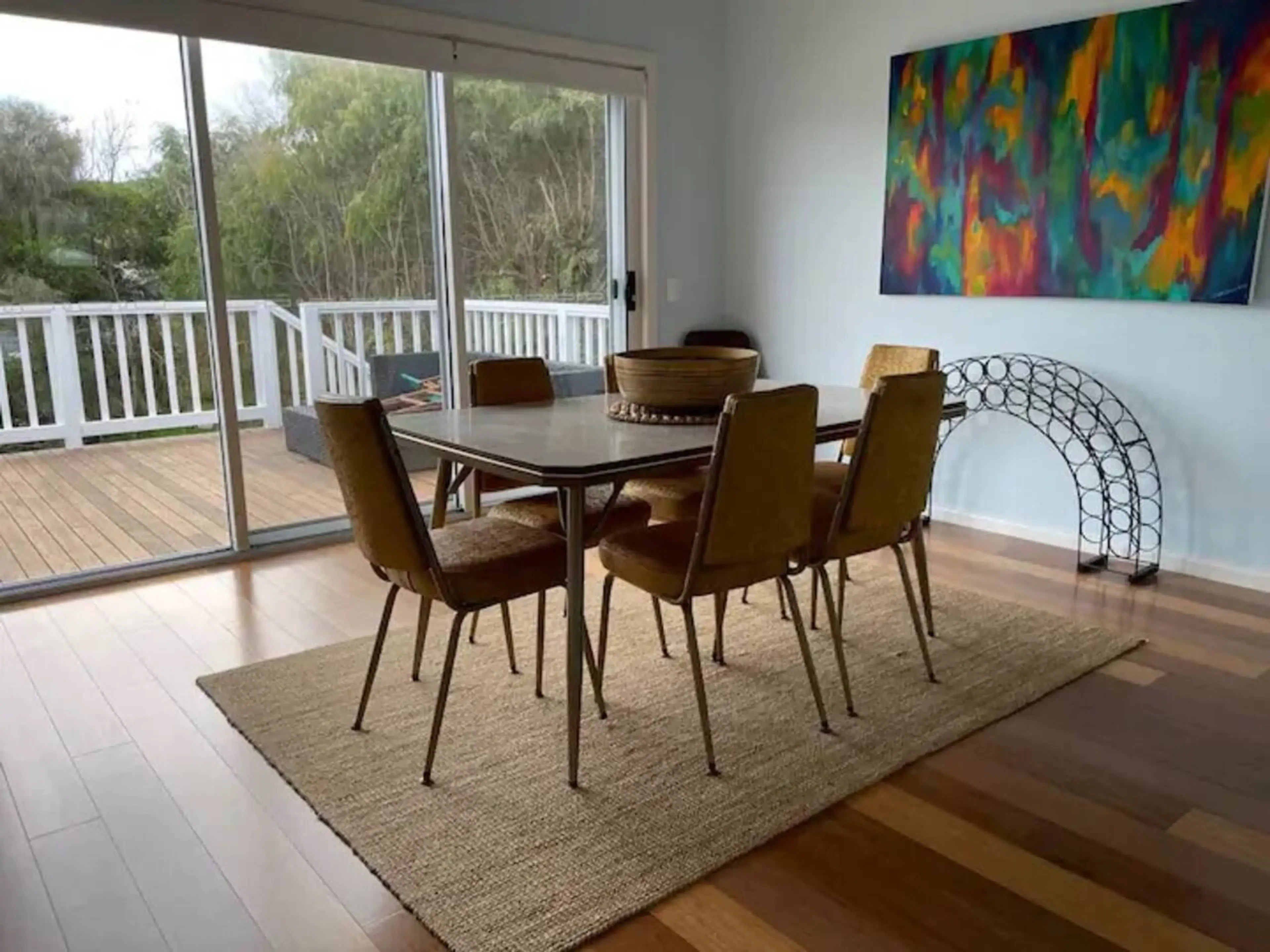 Ocean Blue — retro dining room with colourful artwork and deck view