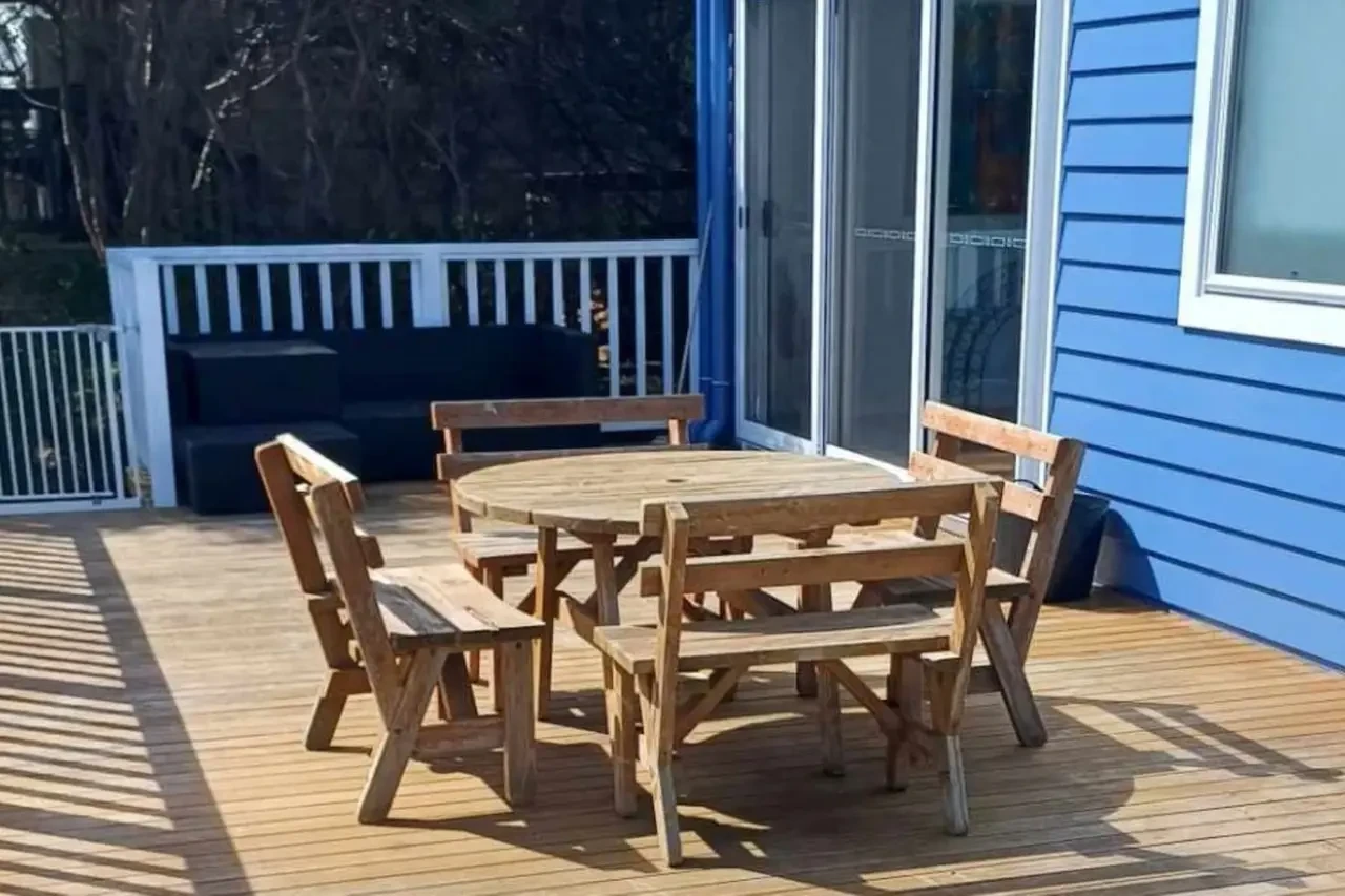 Ocean Blue — outdoor deck with round timber table and bench seats