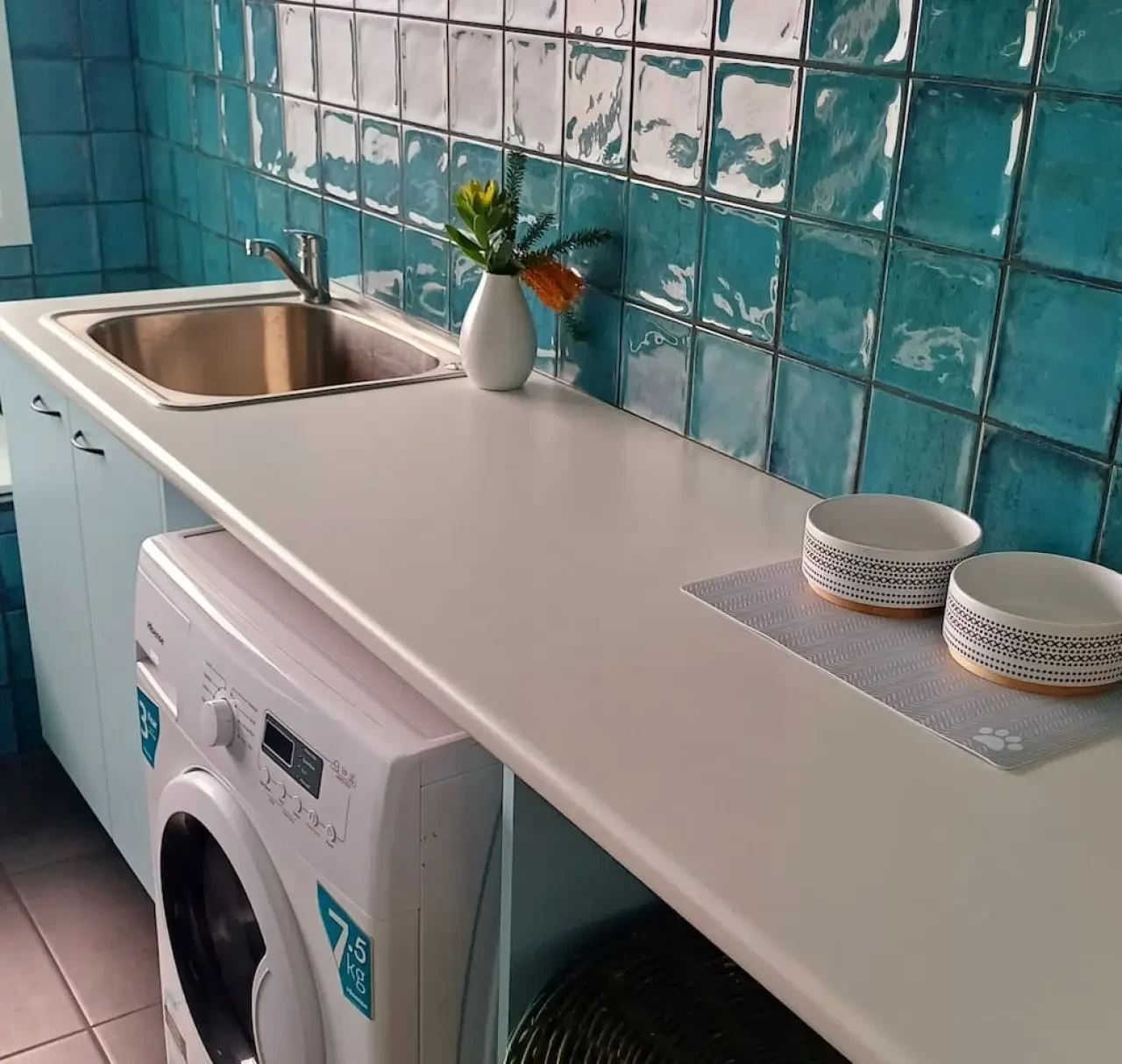 Ocean Blue — laundry with teal tiles, washing machine and pet bowls