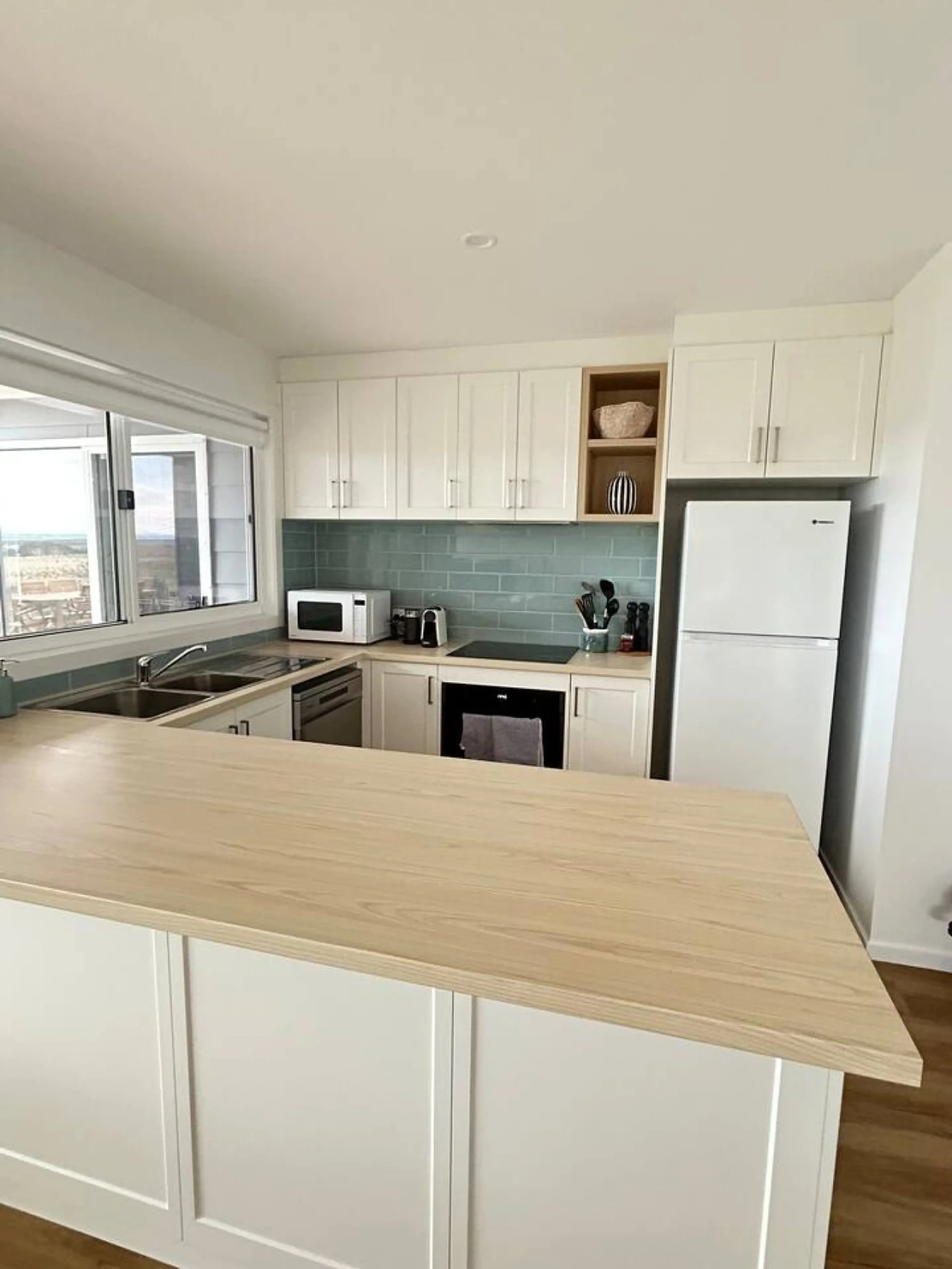 Roo Views kitchen with island bench and teal tiles