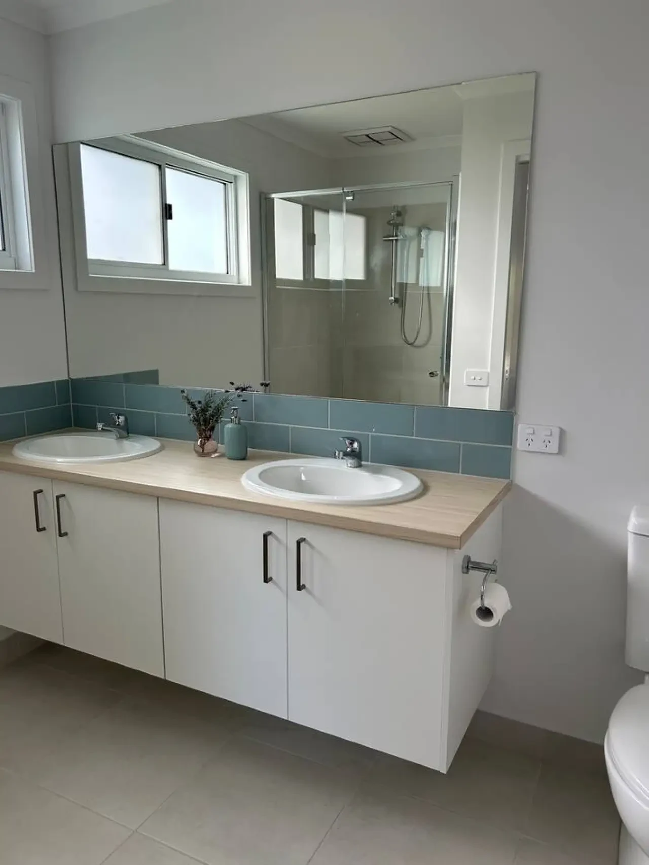Roo Views main bathroom with dual sinks and teal tile splashback