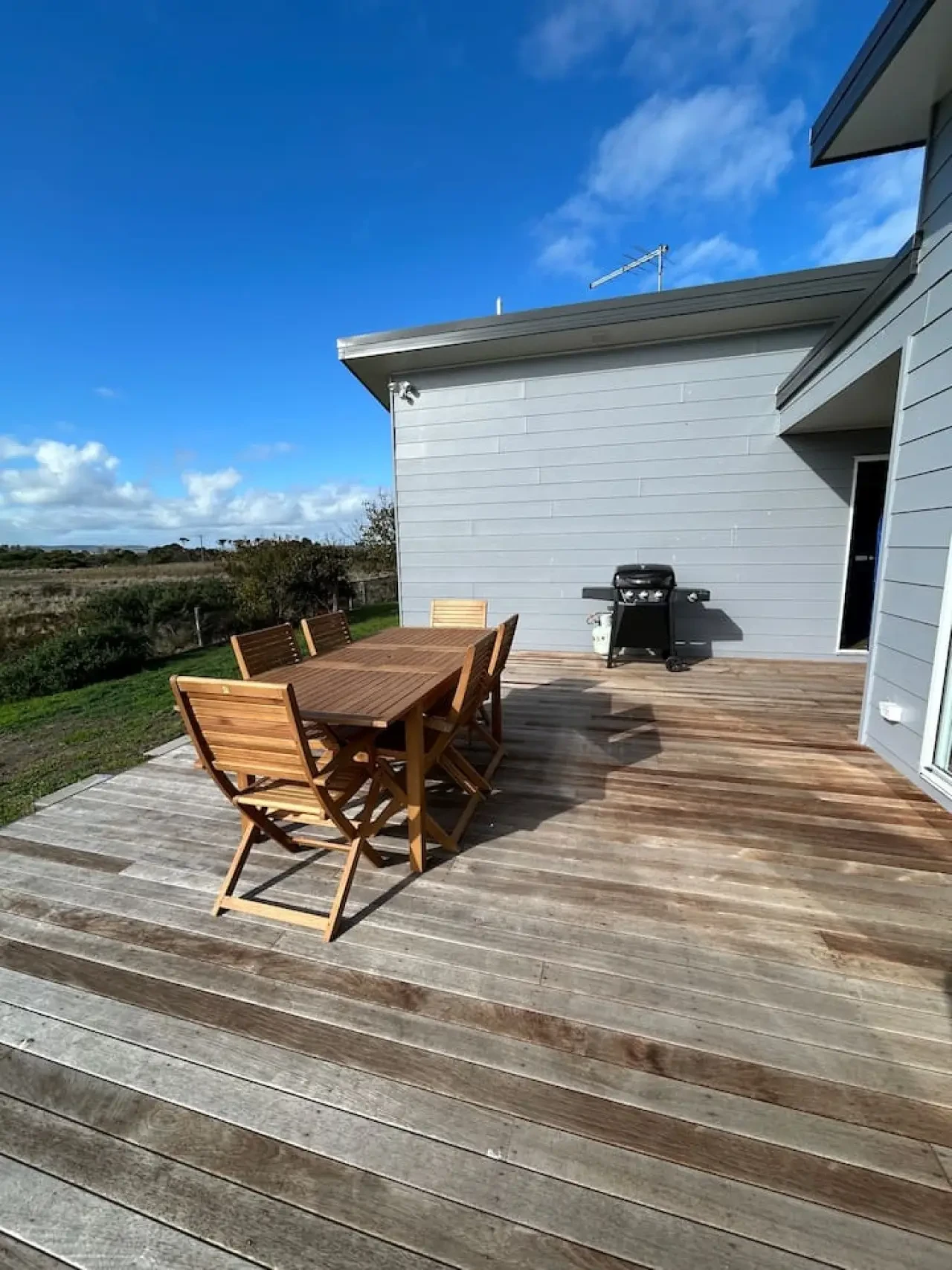 Roo Views deck with teak dining set and blue sky views