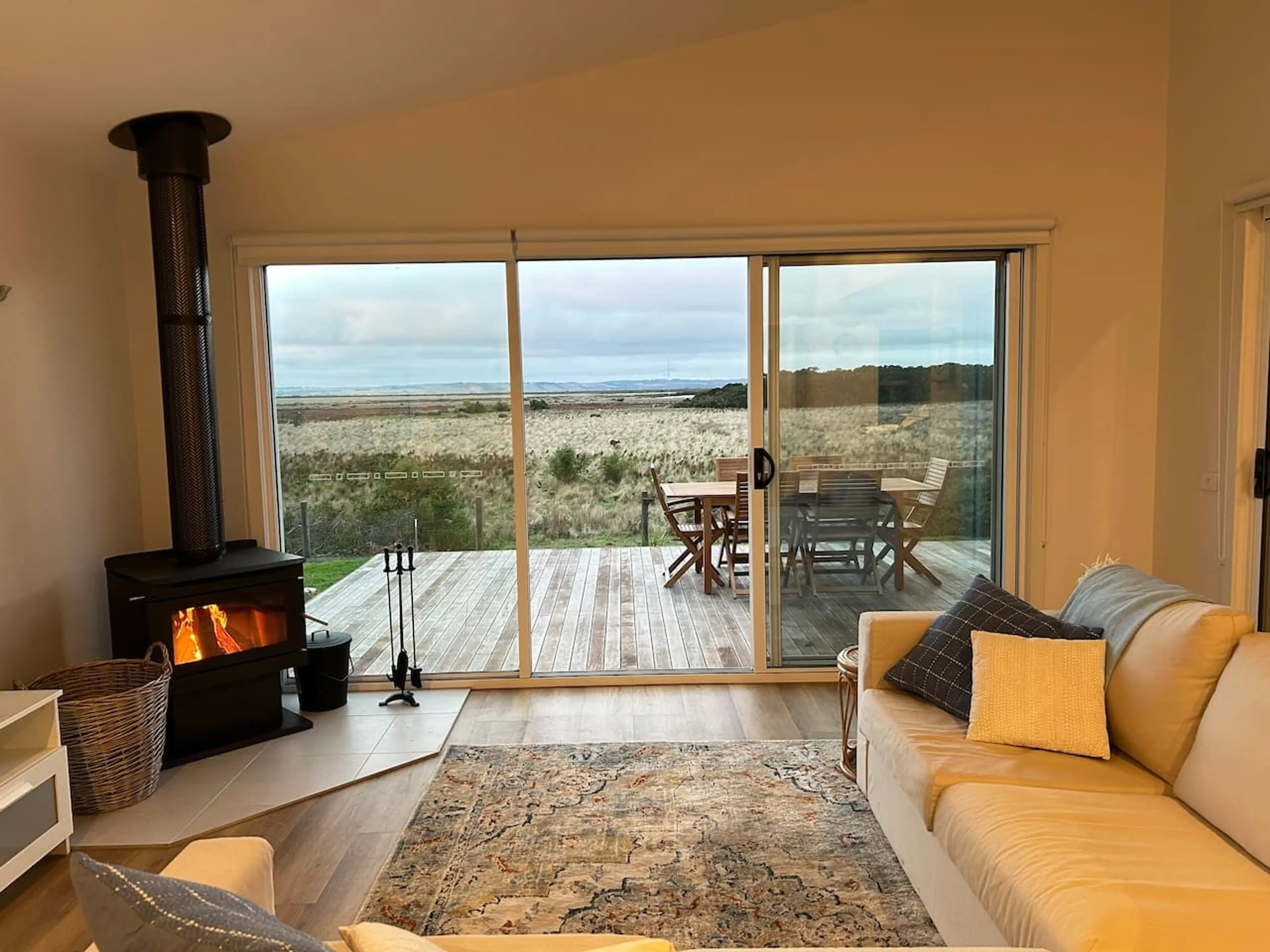 Roo Views living room with wood fire and coastal views