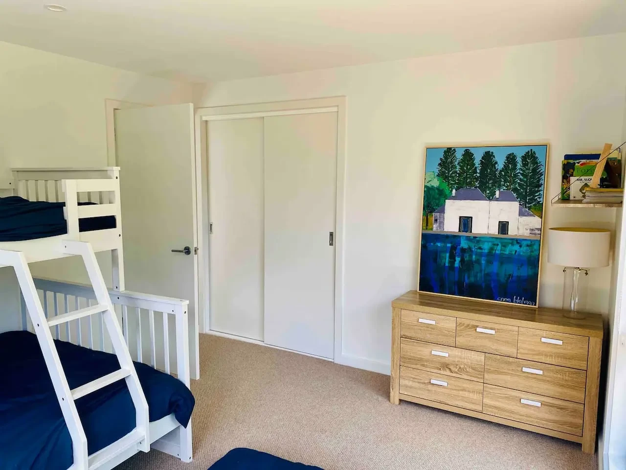 Bedroom with bunk beds and coastal artwork