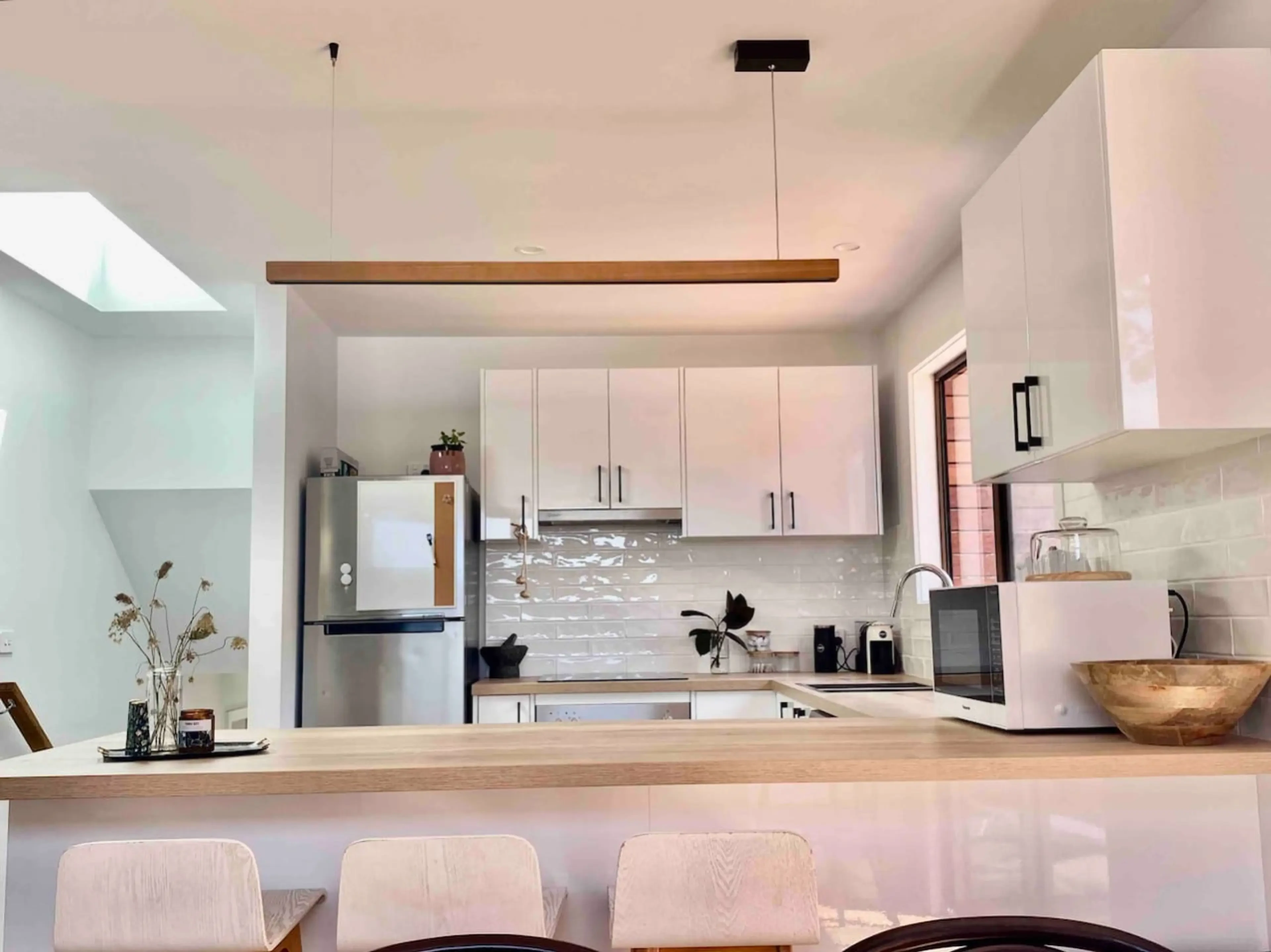 Modern kitchen with white cabinetry and timber benchtop