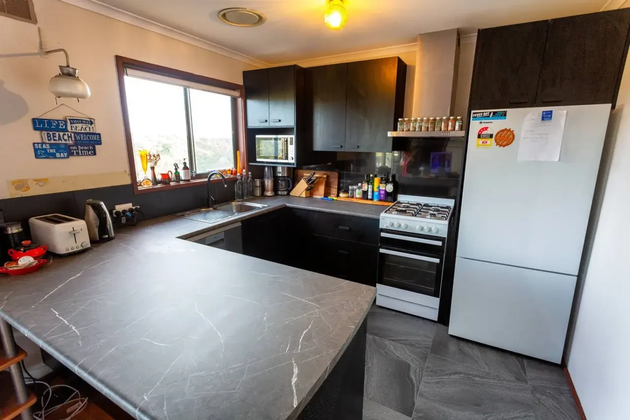 Retro Dunes kitchen with black cabinets marble countertop